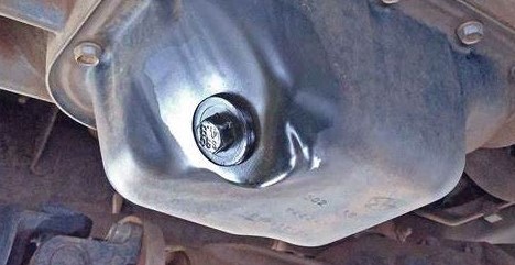 Close-up of the oil drain plug on the vehicle's oil pan.