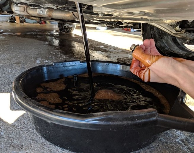 Close-up of the oil pan with the drain plug removed.
