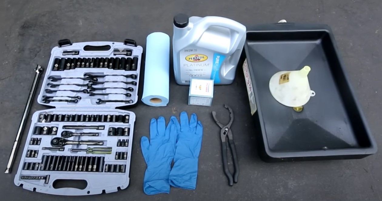 Tools required for changing vehicle oil, including a socket set, oil filter, and oil catch pan.